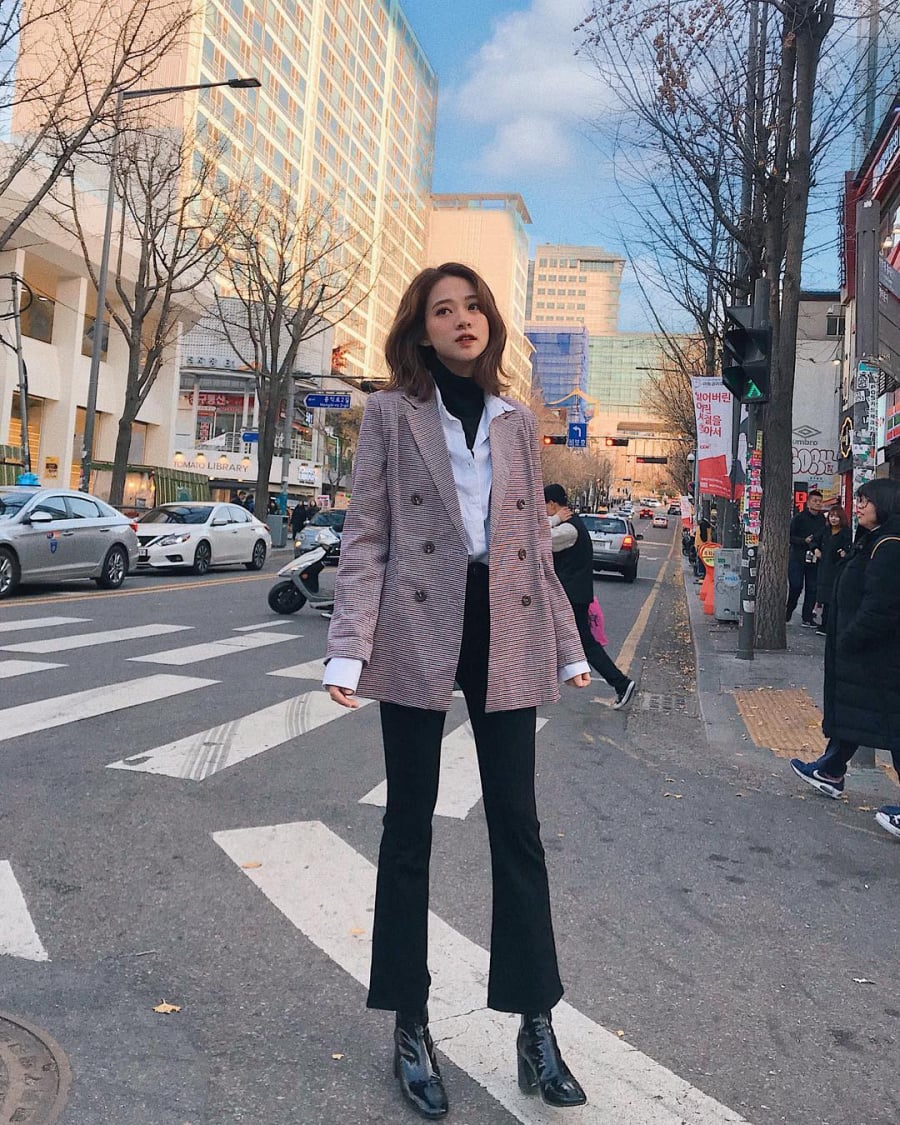 Áo blazer và quần ống loe vốn dĩ không phải là cách kết hợp xa lạ, nhưng bạn hãy thử  nhấn nhá thêm sơ mi và áo len cổ lọ màu đen bên trong mà xem, đảm bảo sẽ 