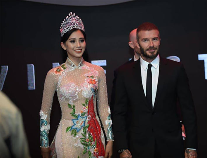 Đội vương miện và diện trong chiếc áo dài được thiết kế cầu kỳ mang nét văn hoá đậm chất dân tộc, Hoa hậu Trần Tiểu Vy rạng rỡ với nụ cười toả nắng sánh đôi cùng cựu danh thủ David Beckham khiến nhiều fan  không khỏi ngưỡng mộ và thích thú. (danviet)