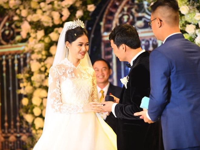 Cặp vợ chồng trao nhau cặp nhẫn cưới trước sự chứng kiến của nhiều người.