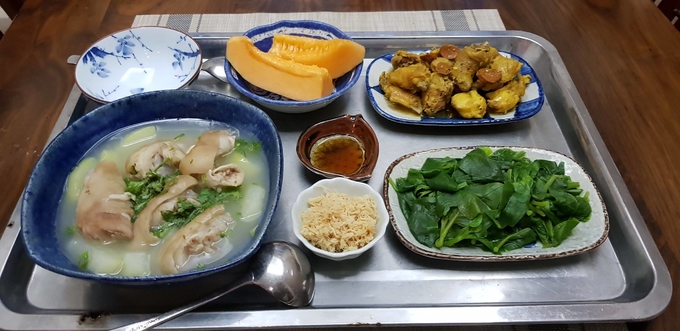 Bữa cơm gồm gà rang gừng nghệ, móng giò hầm đu đủ, rau mồng tơi luộc, ruốc, dưa lưới xanh tráng miệng. Mồng tơi nhà trồng được, mẹ chồng luộc cho con dâu ăn để khỏi táo bón.  