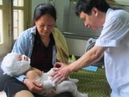 Cháu Dũng (2 tuổi) đang được báo sĩ chăm sóc