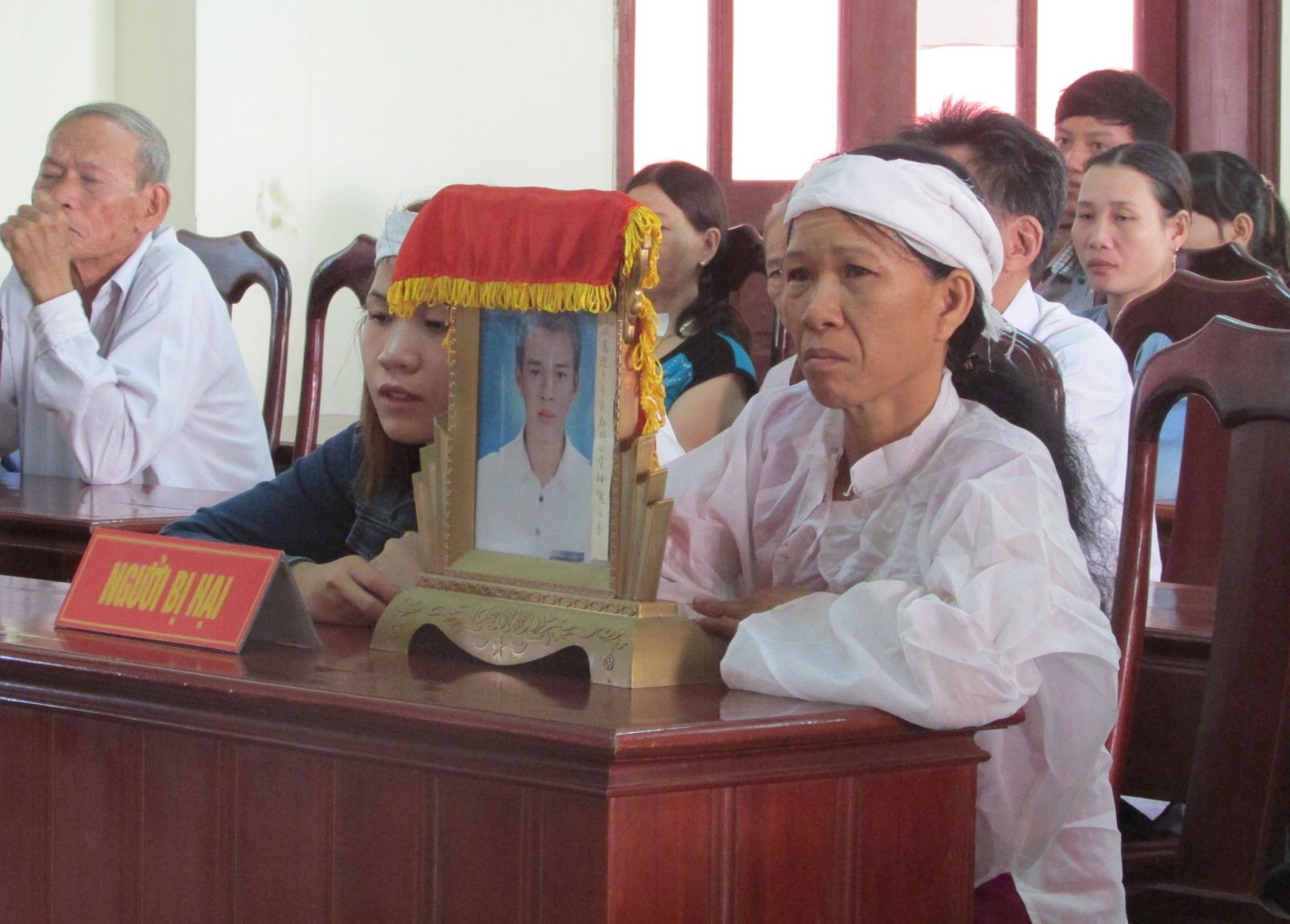 Gia đình anh Đường mang di ảnh nạn nhân tới phiên tòa