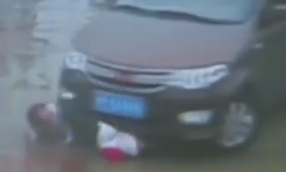 Thót tim 2 em bé đang buộc dây giày bị ôtô cuốn lọt gầm