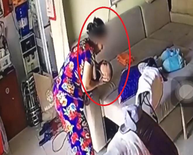 Bà giúp việc nhổ nước bọt vào miệng cháu bé (Ảnh cắt từ clip)