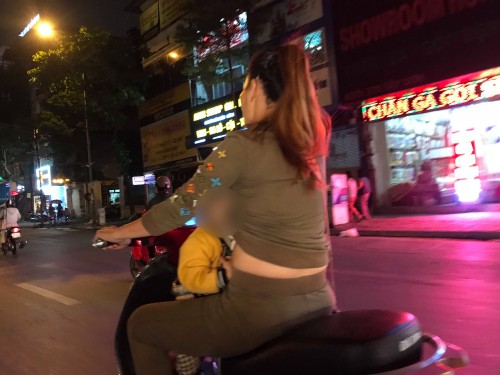 Người mẹ một tay SHBET 1000 World Cup máy, một tay ôm con bú trên đường. Ảnh H.A.