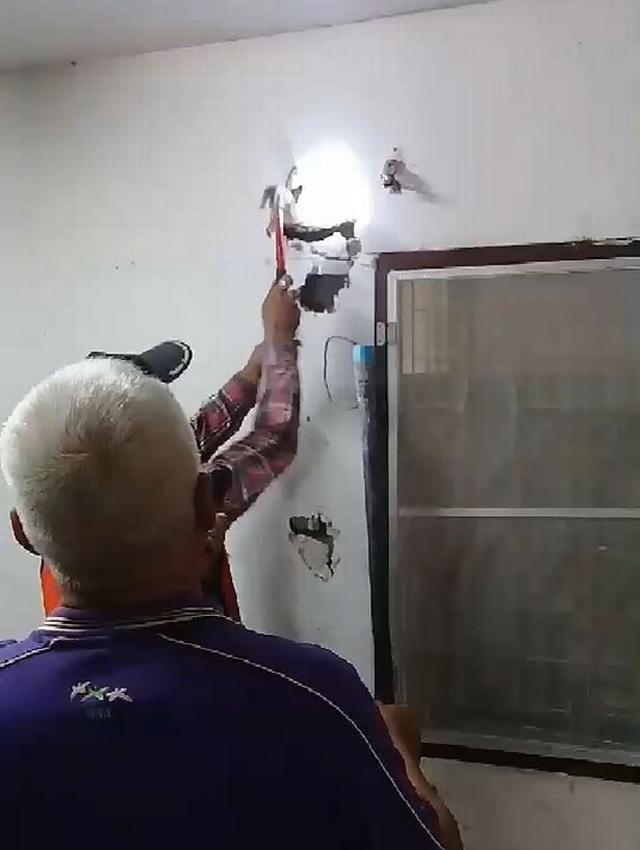Ông Somchai nghe thấy âm thanh kỳ lạ phát ra từ bức tường trong nhà mình và gọi cứu hộ.