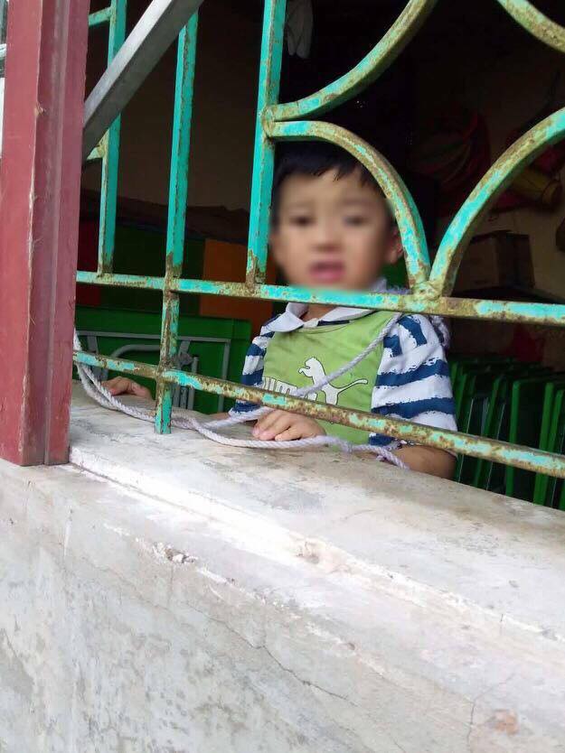 Bé trai bị nhốt và buộc vào cửa sổ trong một góc phòng học .
