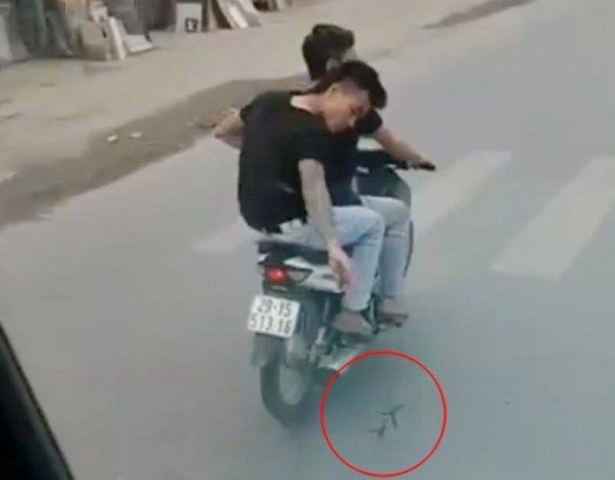 Hình ảnh 2 nam thanh niên rải đinh trước bánh ô tô. 