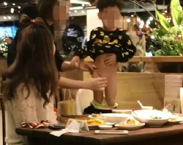 Bé trai được mẹ cho đi tiểu ngay trên bàn ăn.