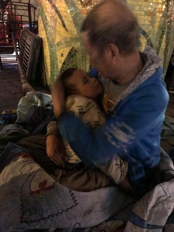 Hình ảnh ông cụ ôm cháu nhỏ ở chân cầu Chương Dương.