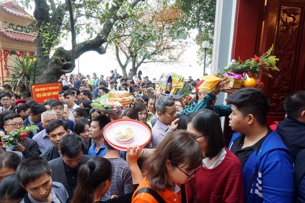 Nhiều dân công sở chuẩn bị tiền vàng, lễ cúng. Do quá đông và chen chúc, nhiều người phải đội lễ lên đầu để tìm cách len lỏi giữa dòng người.