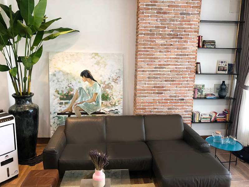 Cấu trúc của căn nhà có 3 tầng, 1 trệt, rộng 300 m2. Phần nền không lót gạch, để nguyên chất liệu xi-măng. Mảng tường được ốp gạch nung, mang lại cảm giác mộc mạc.